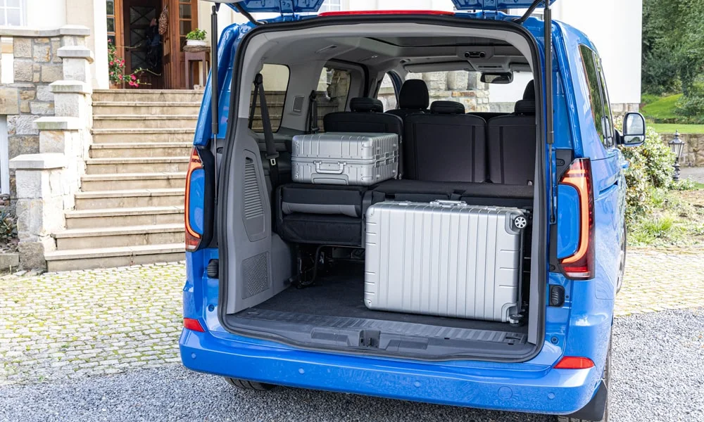 Фото Volkswagen Caravelle (2024) — багажник. Форма проёма, ровный пол и организация пространства. Спинки второго ряда складываются и расширяют отсек под длинные грузы Volkswagen Caravelle (2024) — багажник