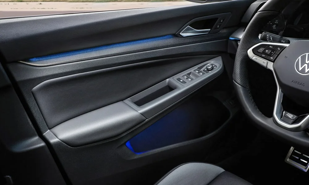 Фото Volkswagen Golf (2024) — дверная карта. Дверная карта в тёмно-синей отделке: подлокотник, динамик и блок стеклоподъёмников. Мягкая вставка в зоне локтя — то, что чувствуешь каждый день Volkswagen Golf (2024) — дверная карта