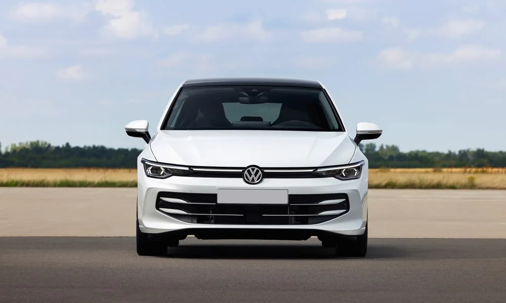 Фото Volkswagen Golf (2024) — вид спереди, фото 3. Кузов в белом цвете: рисунок оптики и решётки задаёт узнаваемое «лицо» модели. Дневные ходовые огни включаются автоматически с запуском Volkswagen Golf (2024) — вид спереди, фото 3