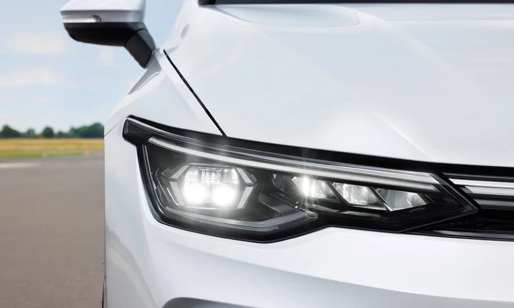 Фото Volkswagen Golf (2024) — вид спереди, фото 4. Кузов в белом цвете: рисунок оптики и решётки задаёт узнаваемое «лицо» модели Volkswagen Golf (2024) — вид спереди, фото 4