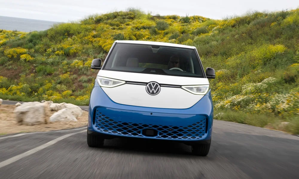 Фото Volkswagen ID Buzz (2024) — вид спереди, фото 6. Анфас: пропорции капота, посадка кузова и графика ходовых огней. Рисунок ходовых огней — подпись модели, по нему её узнают в потоке Volkswagen ID Buzz (2024) — вид спереди, фото 6