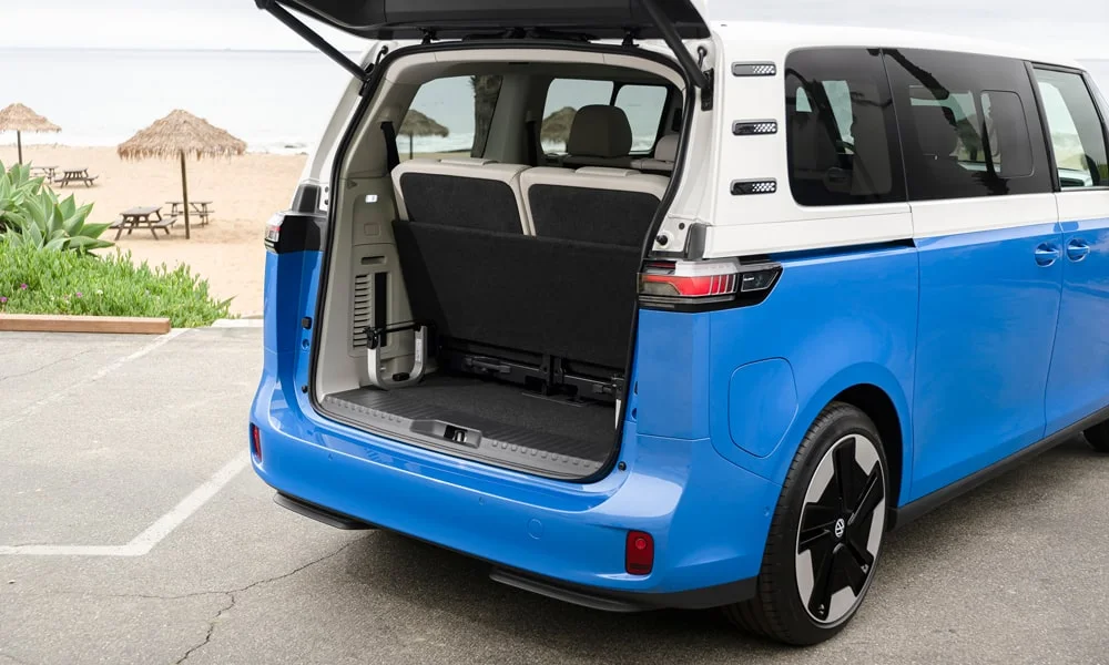 Фото Volkswagen ID Buzz (2024) — багажник. Грузовой отсек с открытой дверью: погрузочная высота и ширина проёма. Под полом обычно размещены органайзер, докатка или ремкомплект Volkswagen ID Buzz (2024) — багажник