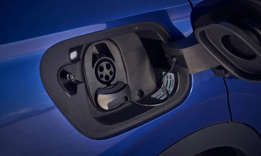 Фото Volkswagen ID 4 — порт зарядки. Зарядный лючок открыт — виден разъём быстрой и медленной зарядки. Крышка порта открывается кнопкой, с экрана или из мобильного приложения Volkswagen ID 4 — порт зарядки