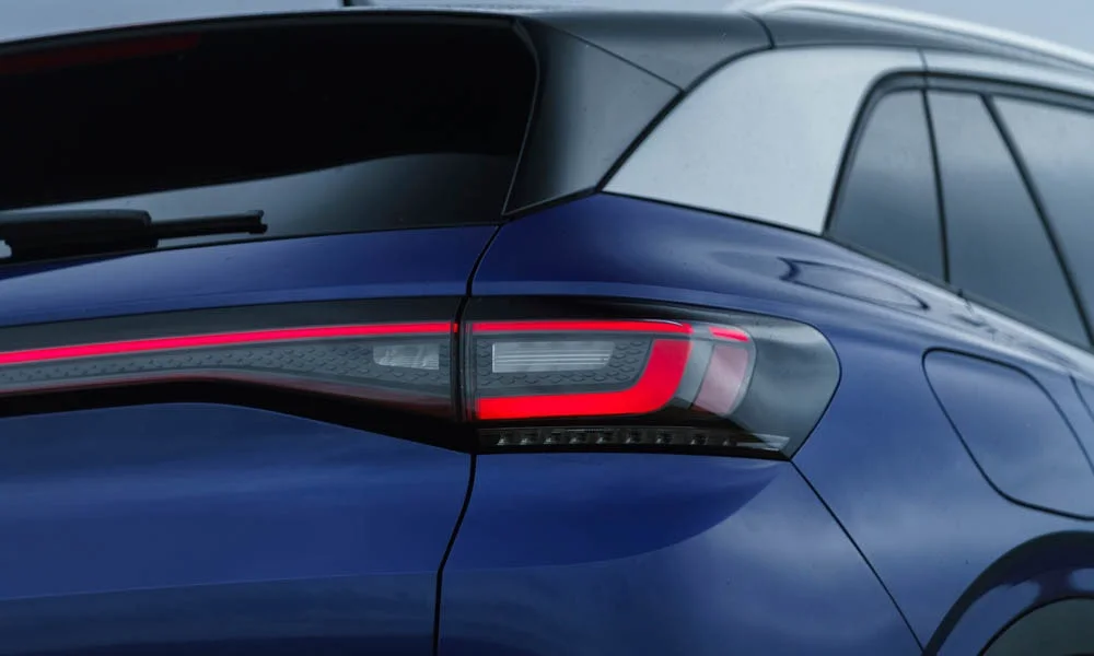 Фото Volkswagen ID 4 — вид сзади, фото 4. Линия крыши, стойки и задняя дверь в синем исполнении. Насадки выхлопа или их имитация внизу бампера различают версии Volkswagen ID 4 — вид сзади, фото 4