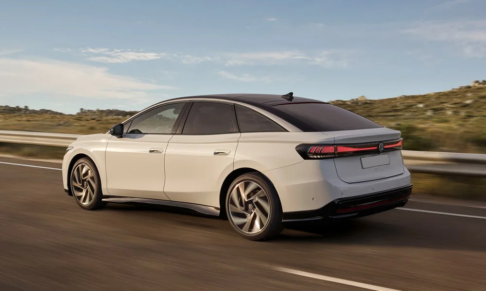 Фото Volkswagen ID 7 (2024) — вид сзади, фото 3. Белый кузов сзади — фонари и бампер определяют ночной образ модели. Насадки выхлопа или их имитация внизу бампера различают версии Volkswagen ID 7 (2024) — вид сзади, фото 3