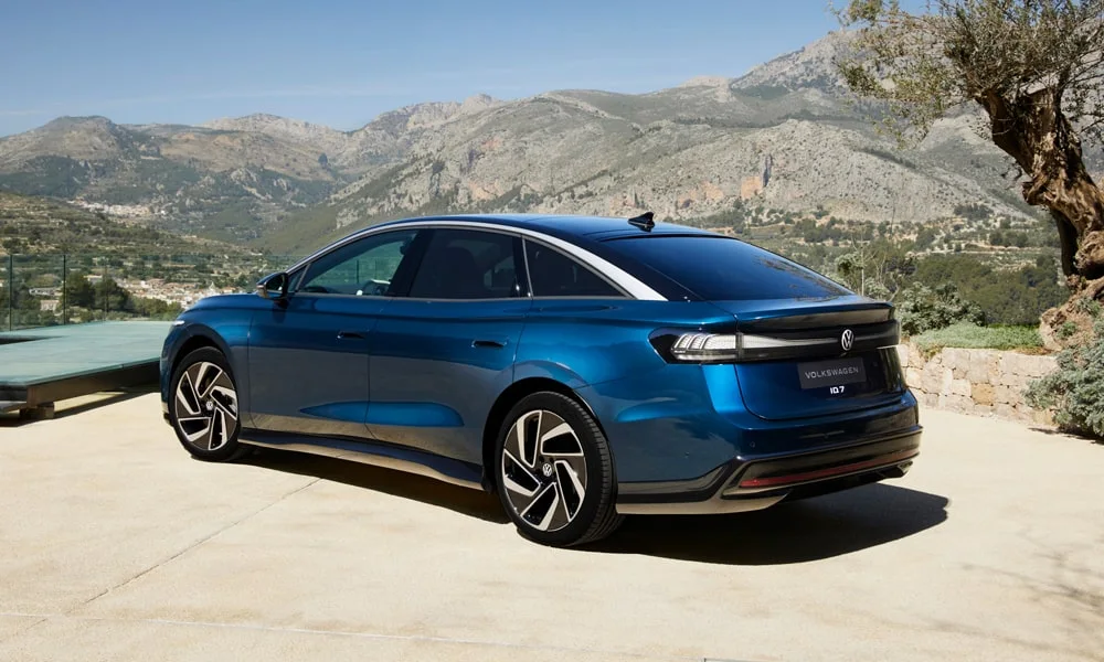 Фото Volkswagen ID 7 (2024) — вид сзади, фото 5. Корма в синем цвете: графика фонарей и пластика пятой двери. Светодиодная полоса или раздельные секции — задняя оптика стала главным украшением кормы Volkswagen ID 7 (2024) — вид сзади, фото 5
