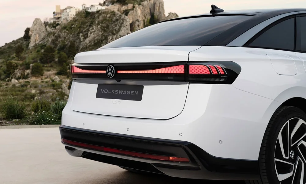 Фото Volkswagen ID 7 (2024) — вид сзади, фото 9. Белый кузов сзади — фонари и бампер определяют ночной образ модели Volkswagen ID 7 (2024) — вид сзади, фото 9