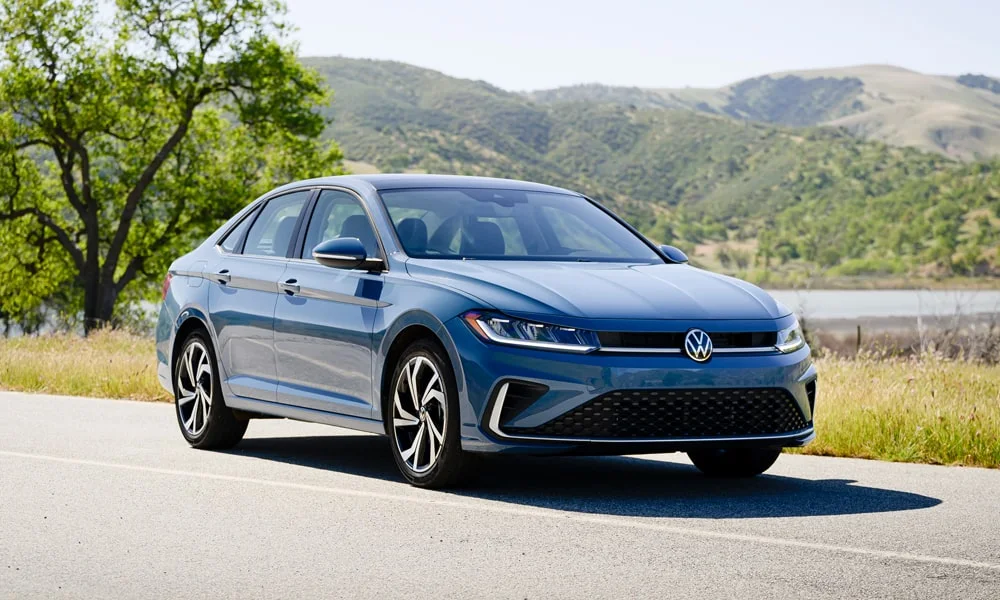Фото Volkswagen Jetta (2024) — вид спереди, фото 8. Синий кузов, строгая симметрия оптики — базовый ракурс знакомства с дизайном Volkswagen Jetta (2024) — вид спереди, фото 8