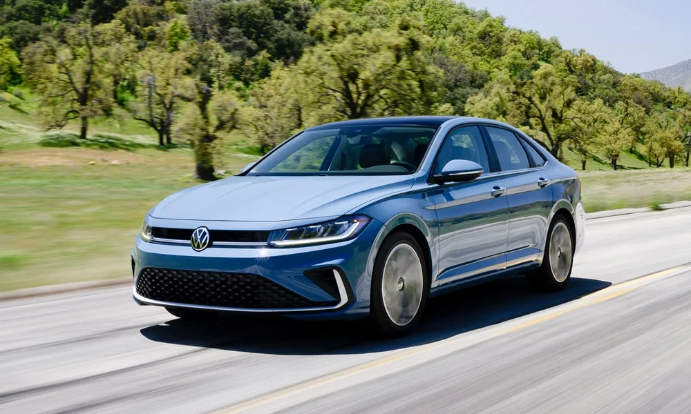 Фото Volkswagen Jetta (2024) — вид спереди, фото 9. Синий кузов, строгая симметрия оптики — базовый ракурс знакомства с дизайном Volkswagen Jetta (2024) — вид спереди, фото 9
