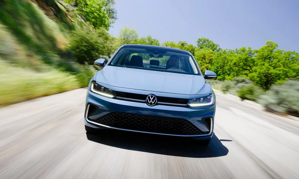 Фото Volkswagen Jetta (2024) — вид спереди, фото 10. Передок в синем исполнении — крупная светотехника и выразительный бампер. Дневные ходовые огни включаются автоматически с запуском Volkswagen Jetta (2024) — вид спереди, фото 10