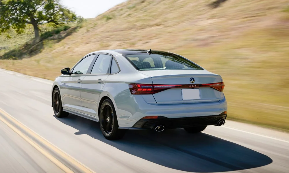 Фото Volkswagen Jetta (2024) — вид сзади, фото 4. Серый кузов сзади — фонари и бампер определяют ночной образ модели. Светодиодная полоса или раздельные секции — задняя оптика стала главным украшением кормы Volkswagen Jetta (2024) — вид сзади, фото 4