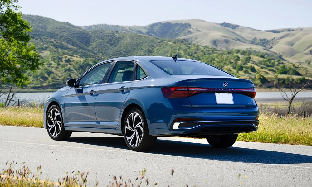 Фото Volkswagen Jetta (2024) — вид сзади, фото 6. Линия крыши, стойки и задняя дверь в синем исполнении. Насадки выхлопа или их имитация внизу бампера различают версии Volkswagen Jetta (2024) — вид сзади, фото 6