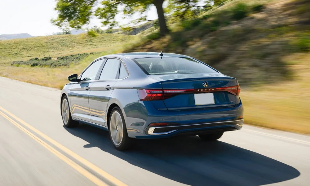 Фото Volkswagen Jetta (2024) — вид сзади, фото 7. Корма в синем цвете: графика фонарей и пластика пятой двери. Светодиодная полоса или раздельные секции — задняя оптика стала главным украшением кормы Volkswagen Jetta (2024) — вид сзади, фото 7