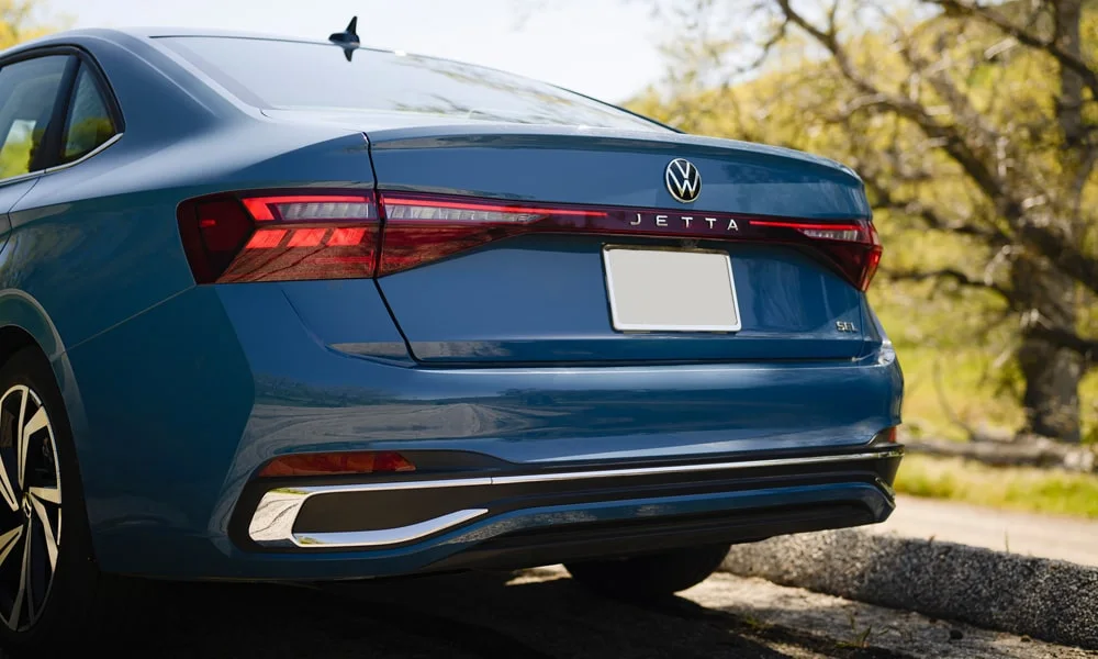 Фото Volkswagen Jetta (2024) — вид сзади, фото 8. Корма в синем цвете: графика фонарей и пластика пятой двери. Светодиодная полоса или раздельные секции — задняя оптика стала главным украшением кормы Volkswagen Jetta (2024) — вид сзади, фото 8