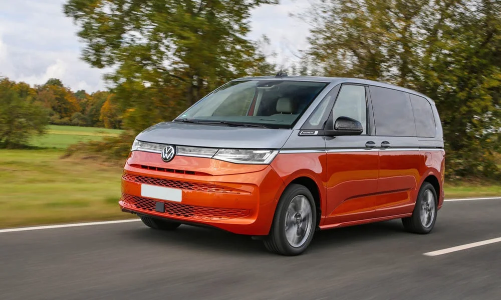 Фото Volkswagen Multivan (2024) — вид спереди, фото 5. Красный кузов, строгая симметрия оптики — базовый ракурс знакомства с дизайном. Дневные ходовые огни включаются автоматически с запуском Volkswagen Multivan (2024) — вид спереди, фото 5