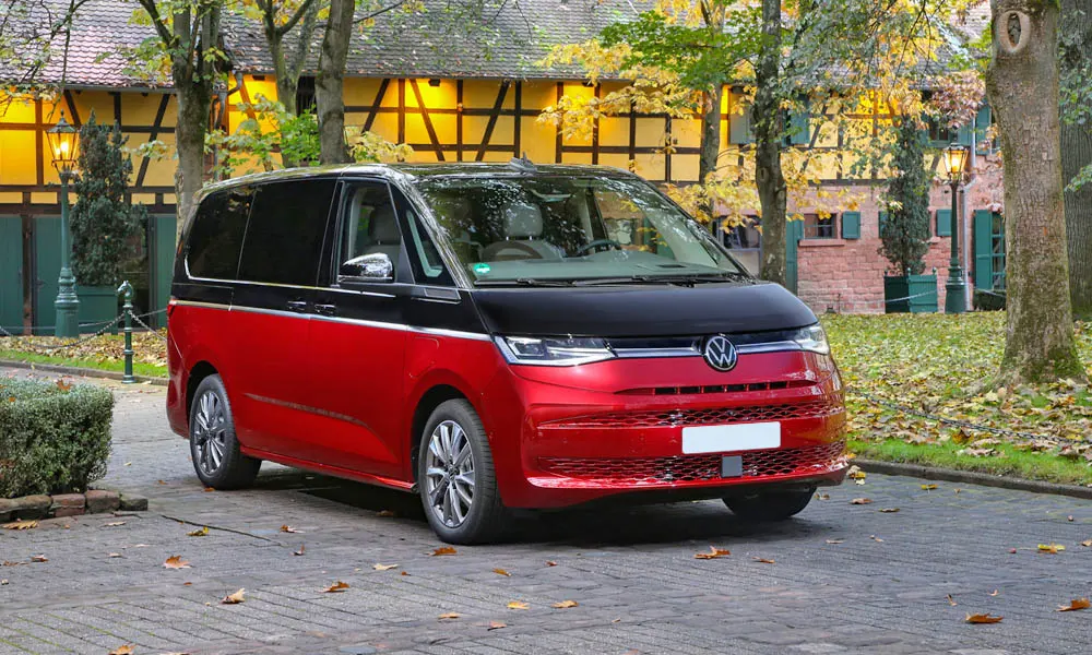 Фото Volkswagen Multivan (2024) — вид спереди, фото 7. Красный кузов, строгая симметрия оптики — базовый ракурс знакомства с дизайном. Дневные ходовые огни включаются автоматически с запуском Volkswagen Multivan (2024) — вид спереди, фото 7