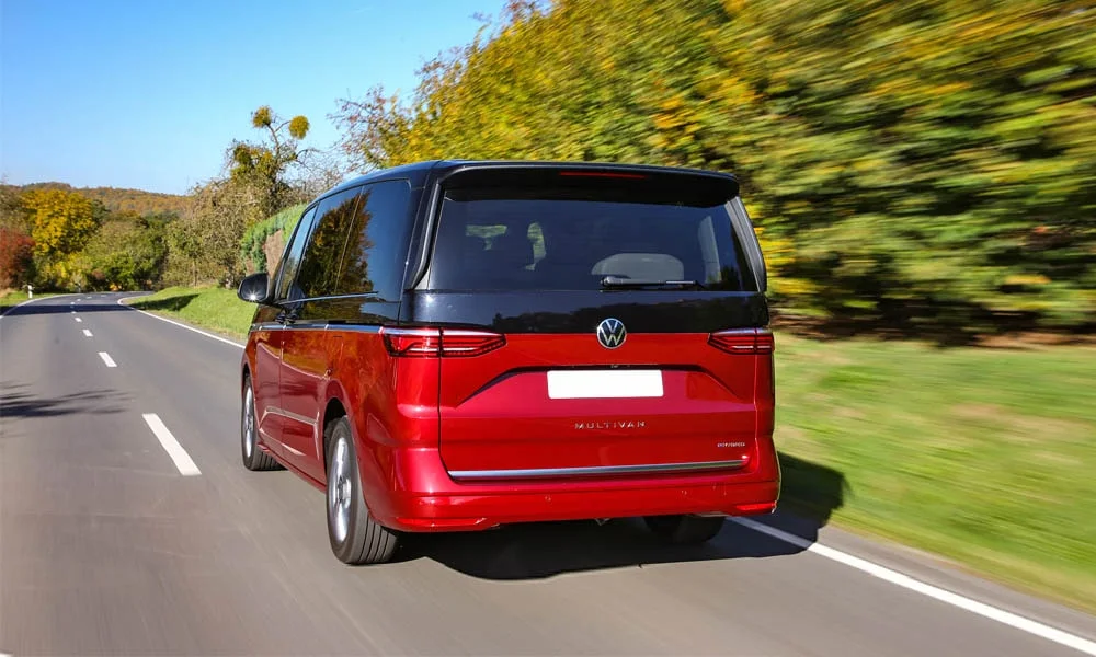 Фото Volkswagen Multivan (2024) — вид сзади, фото 5. Линия крыши, стойки и задняя дверь в красном исполнении Volkswagen Multivan (2024) — вид сзади, фото 5