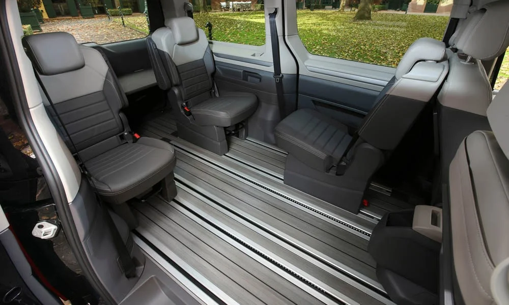Фото Volkswagen Multivan (2024) — задние сиденья, фото 4. Посадка второго ряда: подголовники и подлокотник Volkswagen Multivan (2024) — задние сиденья, фото 4