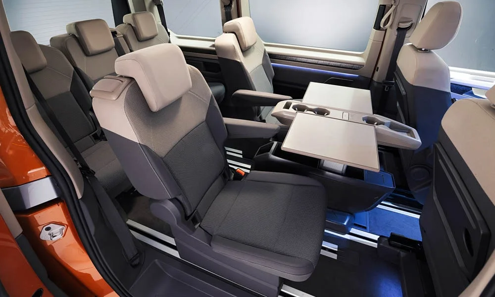 Фото Volkswagen Multivan (2024) — задние сиденья, фото 7. Посадка второго ряда: подголовники и подлокотник. Спинки складываются под длинные грузы у большинства версий Volkswagen Multivan (2024) — задние сиденья, фото 7
