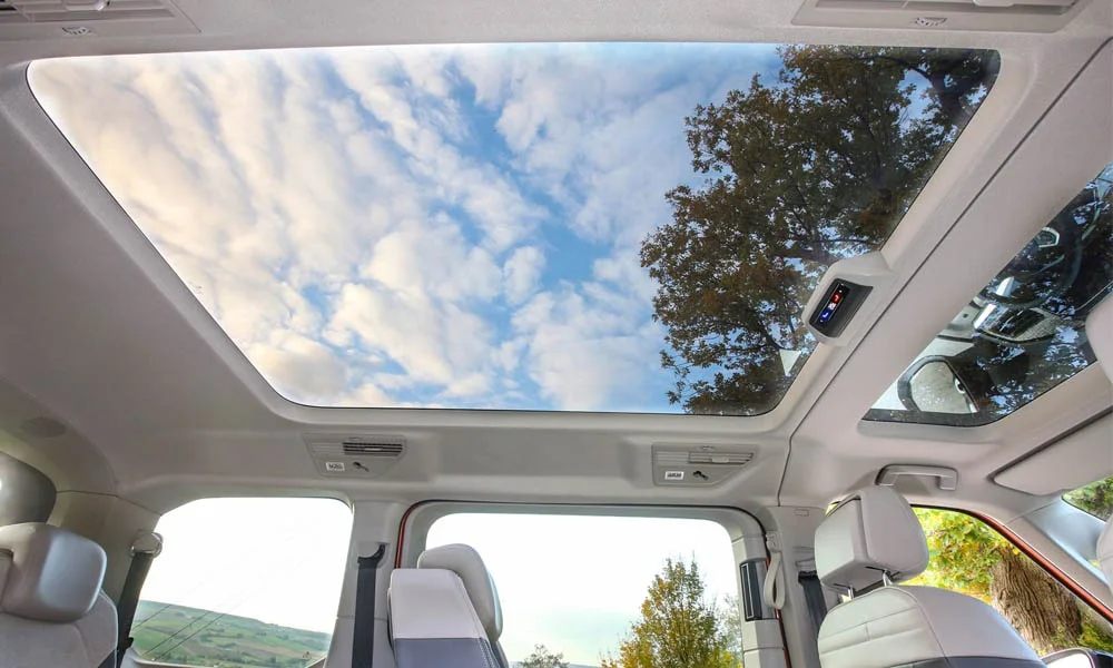 Фото Volkswagen Multivan (2024) — панорамная крыша. Вид на остекление крыши из салона. Люк с функцией проветривания приподнимается задней кромкой Volkswagen Multivan (2024) — панорамная крыша