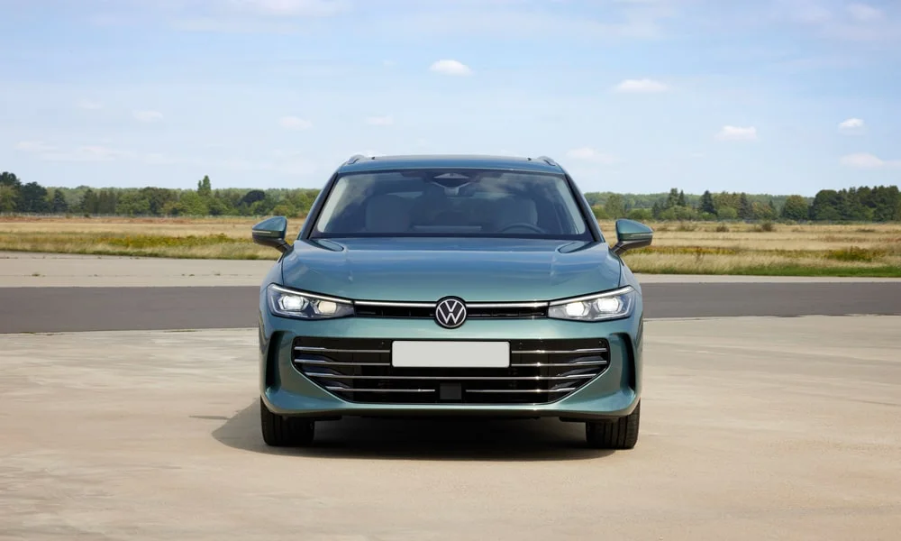 Фото Volkswagen Passat Variant (2024) — вид спереди, фото 4. Зелёный кузов, строгая симметрия оптики — базовый ракурс знакомства с дизайном Volkswagen Passat Variant (2024) — вид спереди, фото 4