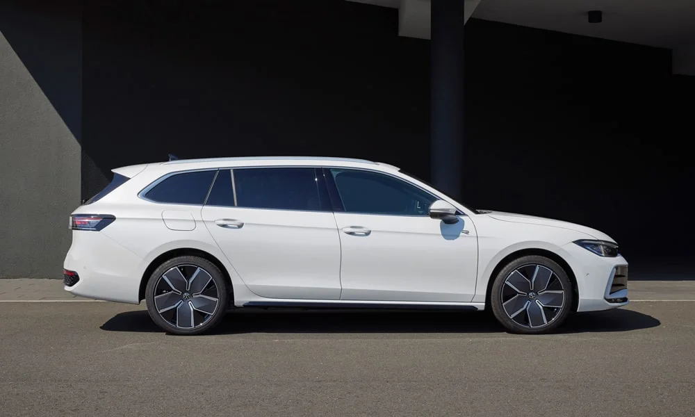 Фото Volkswagen Passat Variant (2024) — вид сбоку, фото 2. Сбоку читаются линия остекления и характер выштамповок на белом кузове. Хромированные или чёрные молдинги окон отличают комплектации Volkswagen Passat Variant (2024) — вид сбоку, фото 2