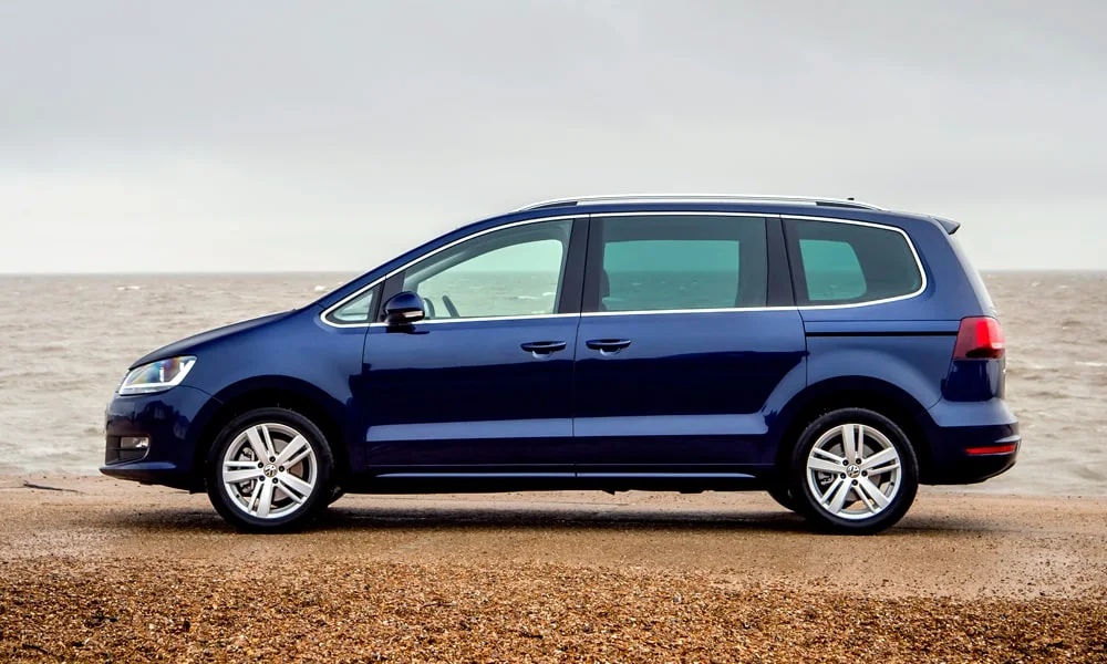 Фото Volkswagen Sharan — вид сбоку, фото 3. Профиль кузова: колёсная база, свесы и линия остекления. Хромированные или чёрные молдинги окон отличают комплектации Volkswagen Sharan — вид сбоку, фото 3