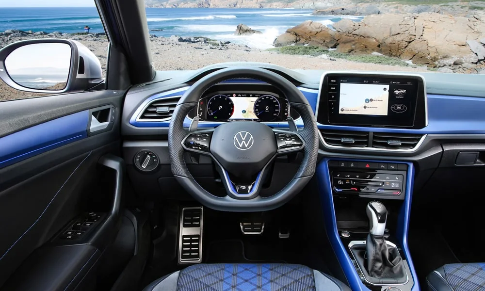 Фото Volkswagen T-Roc — передняя панель. Архитектура передней панели: ярусы, вставки и консоль в тёмно-синей гамме. Мягкие материалы верхнего яруса и вставки задают уровень интерьера Volkswagen T-Roc — передняя панель