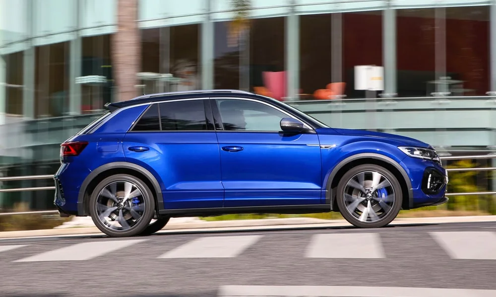Фото Volkswagen T-Roc — вид сбоку, фото 2. Профиль в синем цвете: соотношение колёсной базы и свесов. Хромированные или чёрные молдинги окон отличают комплектации Volkswagen T-Roc — вид сбоку, фото 2