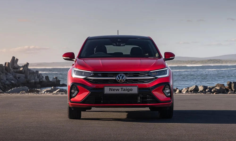 Фото Volkswagen Taigo — вид спереди, фото 6. Красный кузов, строгая симметрия оптики — базовый ракурс знакомства с дизайном. Рисунок ходовых огней — подпись модели, по нему её узнают в потоке Volkswagen Taigo — вид спереди, фото 6