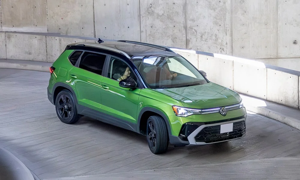 Фото Volkswagen Taos (2024) — вид спереди, фото 8. Кузов в зелёном цвете: рисунок оптики и решётки задаёт узнаваемое «лицо» модели Volkswagen Taos (2024) — вид спереди, фото 8
