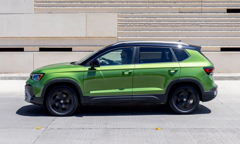 Фото Volkswagen Taos (2024) — вид сбоку. Зелёный кузов в профиль — пропорции, высота посадки и дизайн дисков. Хромированные или чёрные молдинги окон отличают комплектации Volkswagen Taos (2024) — вид сбоку