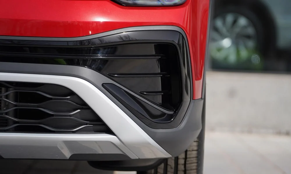 Фото Volkswagen Tharu (2024) — решётка радиатора. Фирменный рисунок облицовки — визитная карточка марки. Активные жалюзи за решёткой закрываются на трассе ради аэродинамики — есть у ряда моделей Volkswagen Tharu (2024) — решётка радиатора