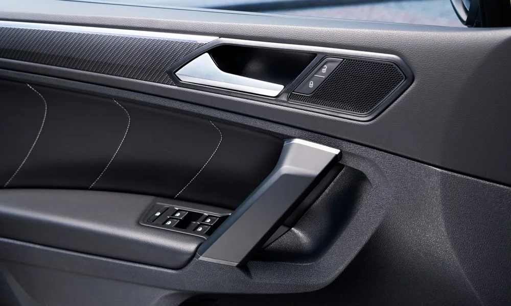 Фото Volkswagen Tiguan Allspace (2024) — дверная карта. Подлокотник, динамик и блок стеклоподъёмников. Решётка динамика в двери — часть штатной акустики Volkswagen Tiguan Allspace (2024) — дверная карта