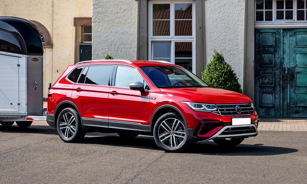 Фото Volkswagen Tiguan Allspace (2024) — вид спереди, фото 6. Передок в красном исполнении — крупная светотехника и выразительный бампер. Дневные ходовые огни включаются автоматически с запуском Volkswagen Tiguan Allspace (2024) — вид спереди, фото 6