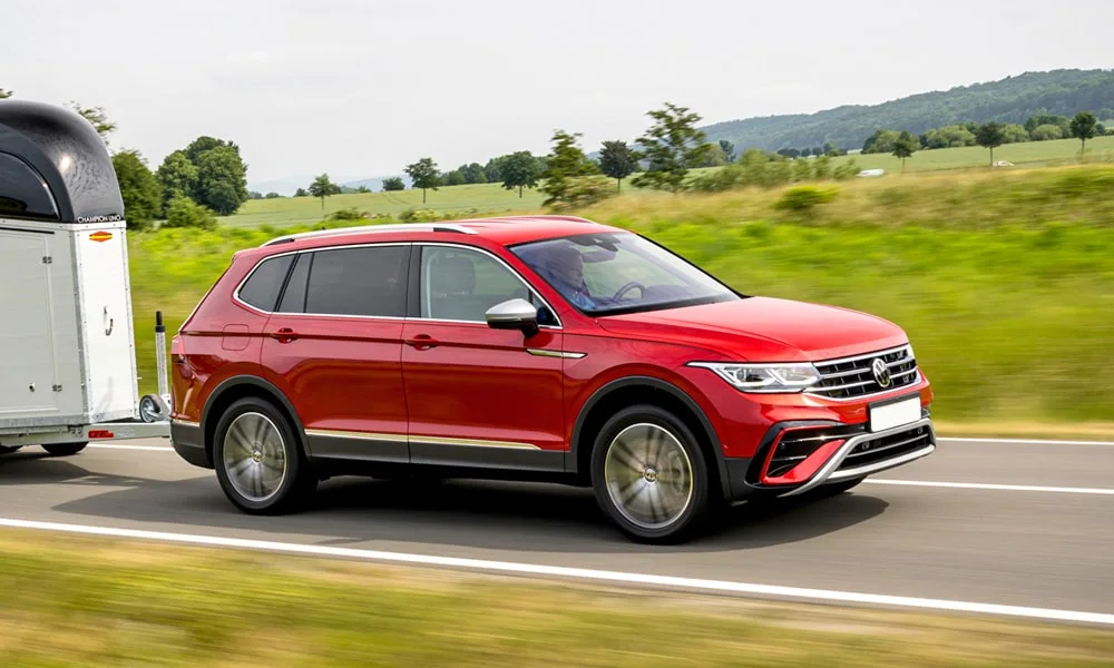 Фото Volkswagen Tiguan Allspace (2024) — вид спереди, фото 8. Передок в красном исполнении — крупная светотехника и выразительный бампер. Дневные ходовые огни включаются автоматически с запуском Volkswagen Tiguan Allspace (2024) — вид спереди, фото 8