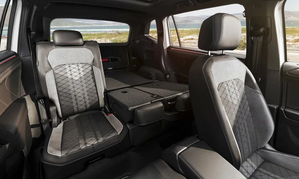 Фото Volkswagen Tiguan Allspace (2024) — интерьер, фото 2. Общий план салона: архитектура панели, консоль и кресла. Светлая гамма зрительно расширяет салон, тёмная — практичнее в уходе Volkswagen Tiguan Allspace (2024) — интерьер, фото 2