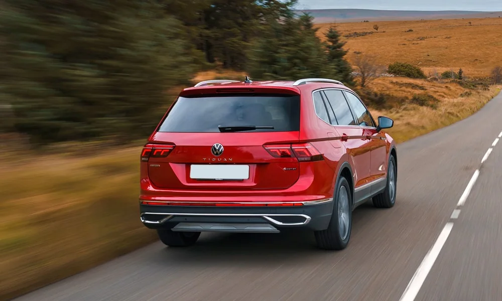 Фото Volkswagen Tiguan Allspace (2024) — вид сзади, фото 3. Линия крыши, стойки и задняя дверь в красном исполнении. Светодиодная полоса или раздельные секции — задняя оптика стала главным украшением кормы Volkswagen Tiguan Allspace (2024) — вид сзади, фото 3