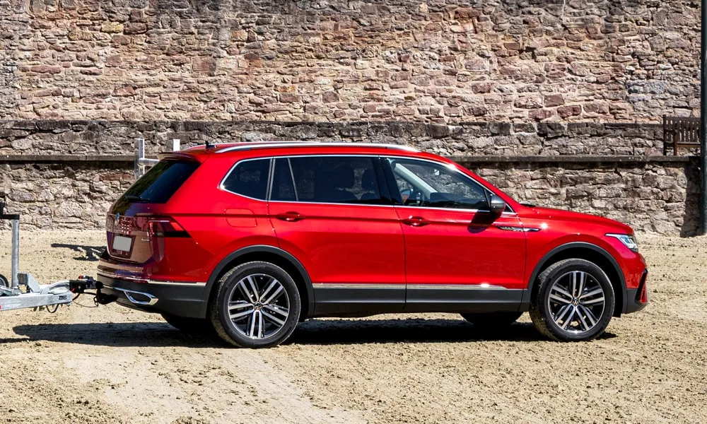 Фото Volkswagen Tiguan Allspace (2024) — вид сзади, фото 4. Корма в красном цвете: графика фонарей и пластика пятой двери. Насадки выхлопа или их имитация внизу бампера различают версии Volkswagen Tiguan Allspace (2024) — вид сзади, фото 4