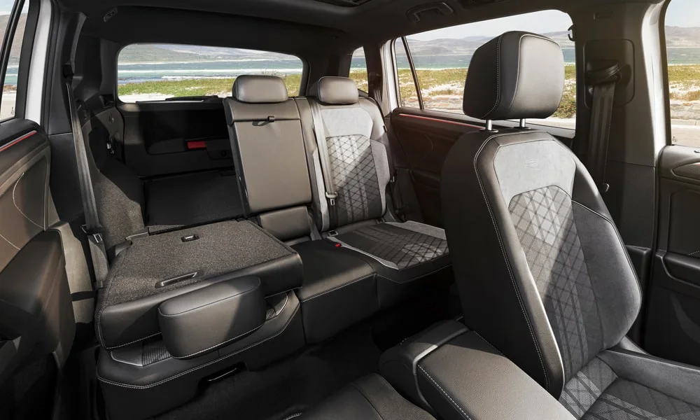Фото Volkswagen Tiguan Allspace (2024) — задние сиденья, фото 2. Второй ряд: профиль дивана, подголовники и обивка из перфорированной коже. Крепления ISOFIX для детских кресел — в основании спинки Volkswagen Tiguan Allspace (2024) — задние сиденья, фото 2