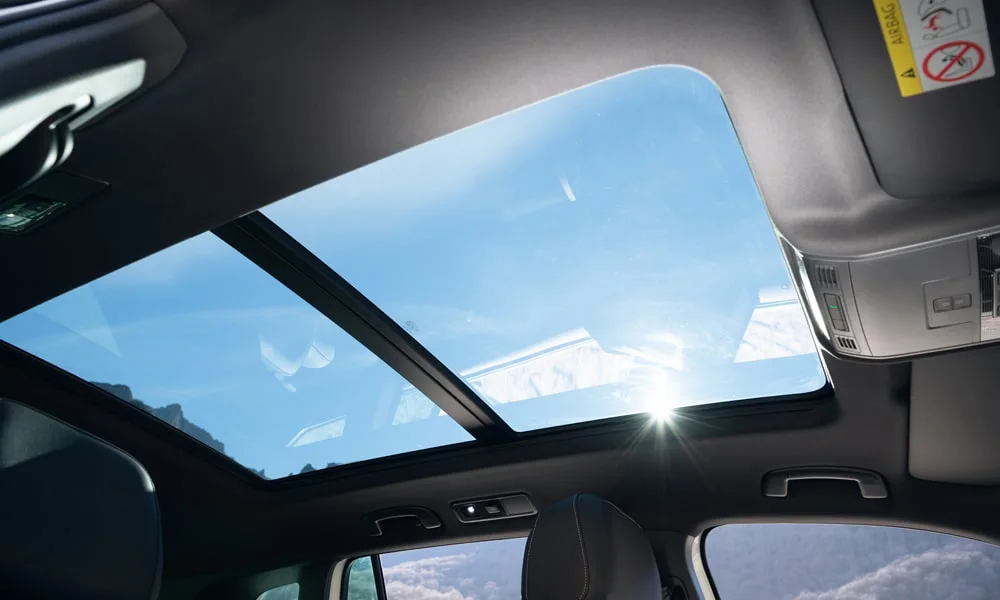 Фото Volkswagen Tiguan Allspace (2024) — панорамная крыша. Вид на остекление крыши из салона. Люк с функцией проветривания приподнимается задней кромкой Volkswagen Tiguan Allspace (2024) — панорамная крыша