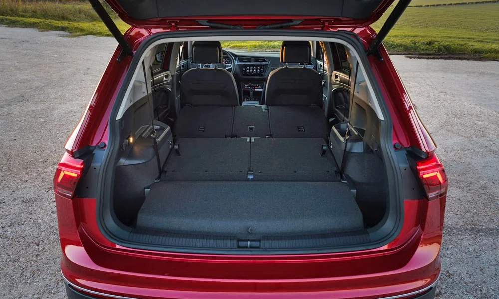 Фото Volkswagen Tiguan Allspace (2024) — багажник, фото 2. Грузовой отсек с открытой дверью: погрузочная высота и ширина проёма. Электропривод двери с датчиком под бампером — руки заняты, багажник открыт Volkswagen Tiguan Allspace (2024) — багажник, фото 2