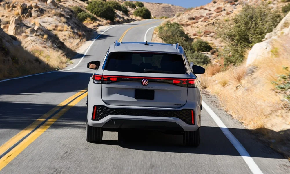 Фото Volkswagen Tiguan (2024) — вид сзади, фото 7. Графика фонарей, бампер и оформление пятой двери. Светодиодная полоса или раздельные секции — задняя оптика стала главным украшением кормы Volkswagen Tiguan (2024) — вид сзади, фото 7