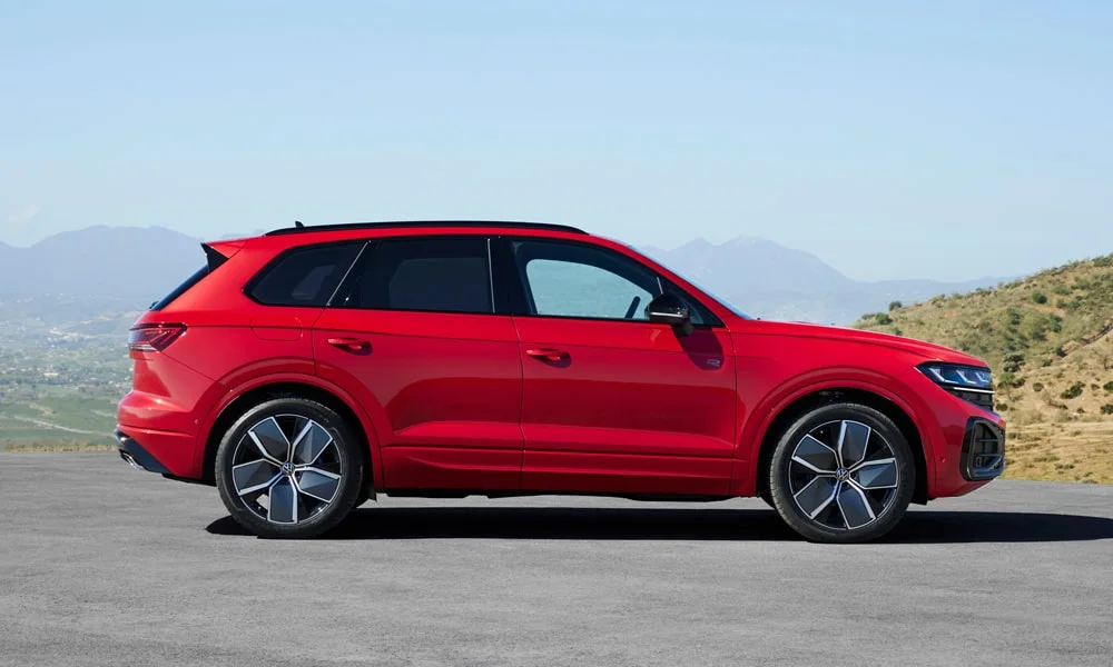 Фото Volkswagen Touareg (2024) — вид сзади, фото 7. Корма в красном цвете: графика фонарей и пластика пятой двери. Светодиодная полоса или раздельные секции — задняя оптика стала главным украшением кормы Volkswagen Touareg (2024) — вид сзади, фото 7