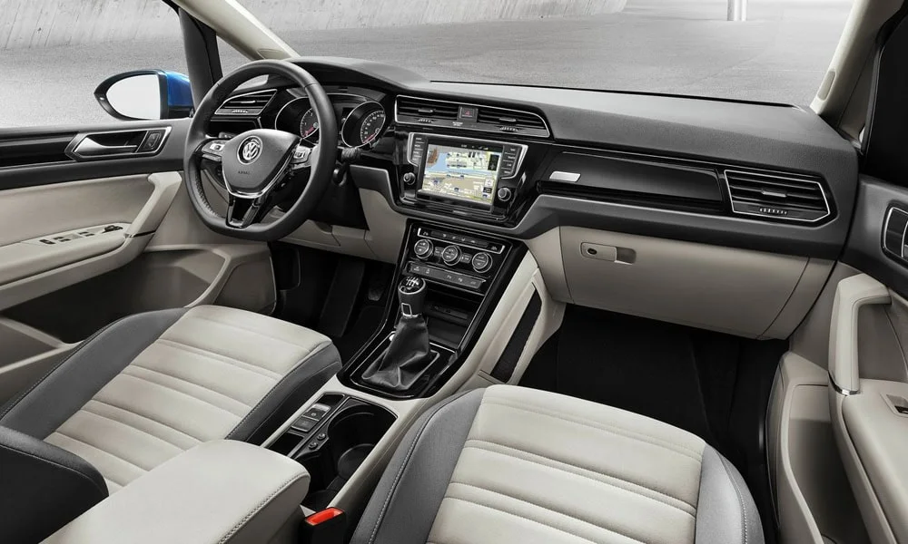 Фото Volkswagen Touran — передняя панель, фото 3. Панель в светлой бежевой отделке — видна компоновка экранов и органов управления. Минимум физических кнопок — ставка на экранное управление Volkswagen Touran — передняя панель, фото 3