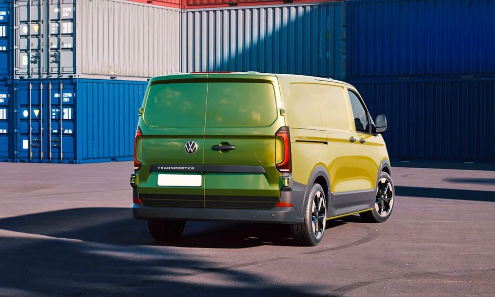 Фото Volkswagen Transporter (2024) — вид сзади, фото 5. Линия крыши, стойки и задняя дверь в зелёном исполнении. Насадки выхлопа или их имитация внизу бампера различают версии Volkswagen Transporter (2024) — вид сзади, фото 5