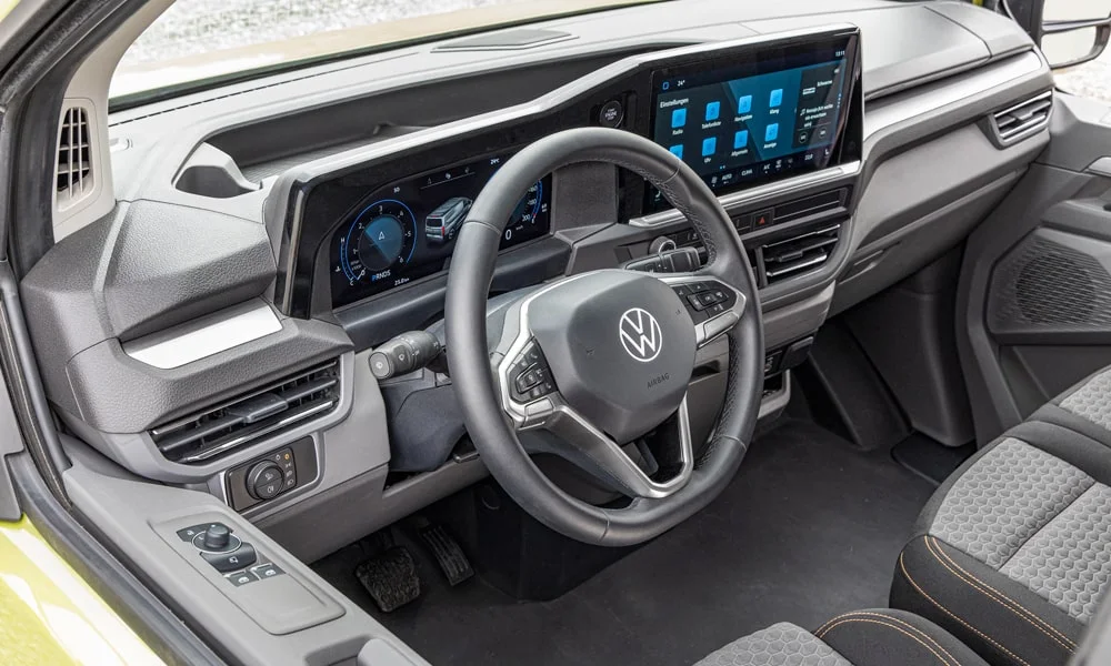 Фото Volkswagen Transporter (2024) — руль. Обшивка обода и компоновка спиц крупным планом. Обогрев обода — опция, которую оценят зимой Volkswagen Transporter (2024) — руль