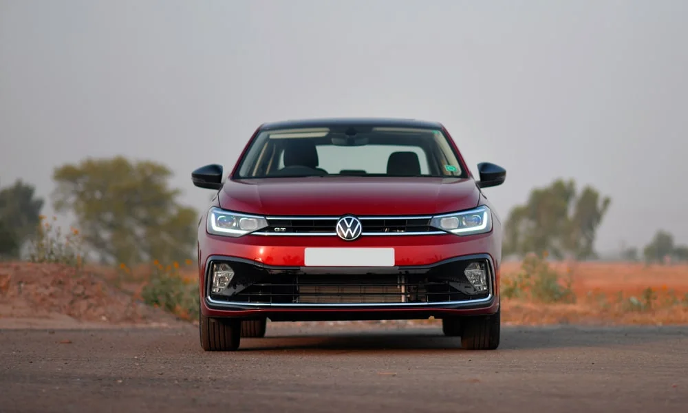 Фото Volkswagen Virtus (2024) — вид спереди, фото 9. Передок в красном исполнении — крупная светотехника и выразительный бампер. Дневные ходовые огни включаются автоматически с запуском Volkswagen Virtus (2024) — вид спереди, фото 9