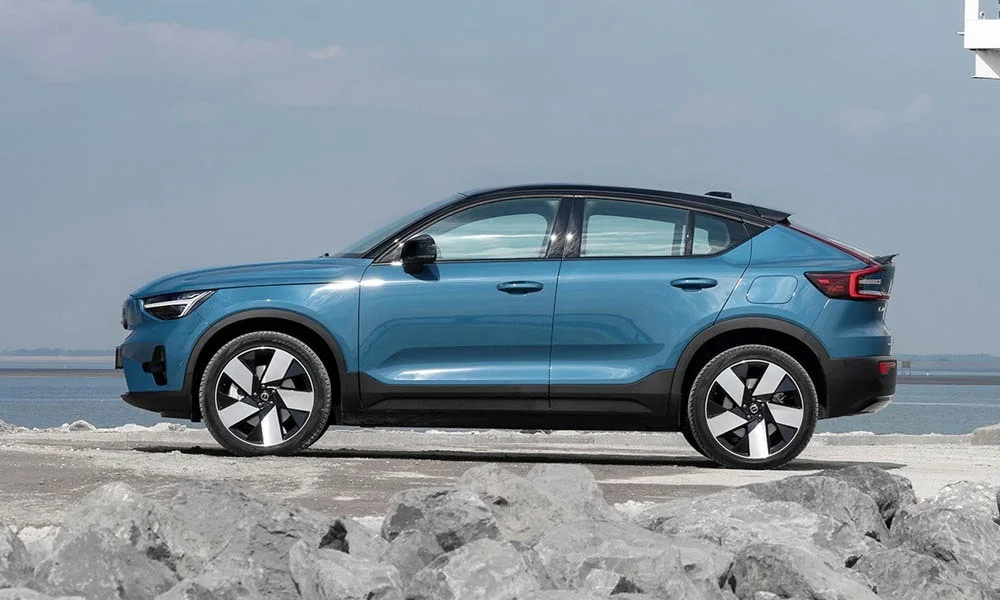 Фото Volvo EM90 (2024) — вид сбоку, фото 5. Сбоку читаются линия остекления и характер выштамповок на синем кузове. Хромированные или чёрные молдинги окон отличают комплектации Volvo EM90 (2024) — вид сбоку, фото 5
