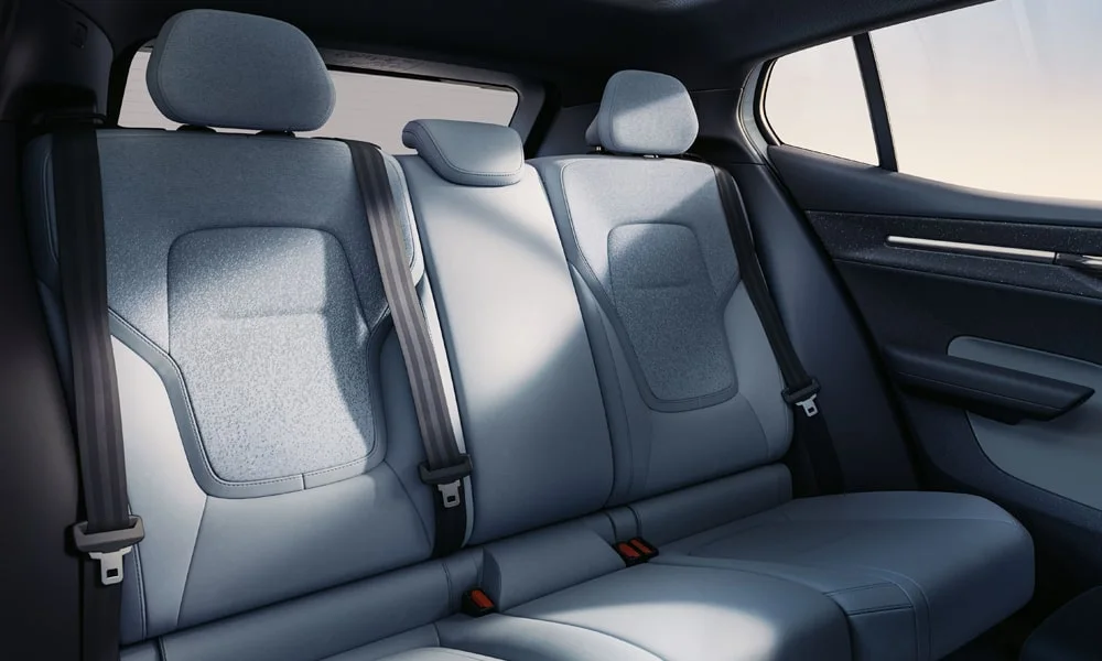 Фото Volvo EX30 — задние сиденья, фото 2. Задний диван в алькантаре: посадка и центральный подлокотник. Спинки складываются под длинные грузы у большинства версий Volvo EX30 — задние сиденья, фото 2